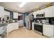 A kitchen features white cabinets, stainless steel appliances, tile flooring, and views into another room at 3372 Springside Rdg, Decatur, GA 30034