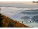 Breathtaking aerial view of a lake and bridge amidst fall foliage and misty mountains at 49 Waterside Se Dr, Cartersville, GA 30121