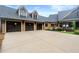 Three-car garage with wood doors and neutral exterior, surrounded by professional landscaping at 49 Waterside Se Dr, Cartersville, GA 30121