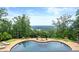 Inviting backyard pool with stone surround and picturesque lake views at 49 Waterside Se Dr, Cartersville, GA 30121