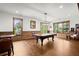 Recreation room featuring a pool table, wood-paneled accents, hardwood floors, and natural light from the large windows at 49 Waterside Se Dr, Cartersville, GA 30121