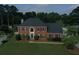 Beautiful two-story brick house with lush green lawn, dark shutters, and arched front door creating a welcoming and elegant entrance at 1197 Kenilworth Trce Trce, Snellville, GA 30078