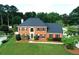 Traditional brick home with manicured lawn, mature trees and black shutters at 1197 Kenilworth Trce Trce, Snellville, GA 30078