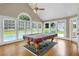 Game room with pool table, hardwood floors, and large windows overlooking backyard at 1197 Kenilworth Trce Trce, Snellville, GA 30078