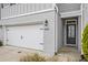 Modern townhome exterior featuring white garage door, gray brick accents, and black front door at 1247 Winterhaven Dr, Cumming, GA 30041