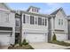 Charming townhome featuring a two-car garage, modern design elements, and well-maintained landscaping at 1247 Winterhaven Dr, Cumming, GA 30041