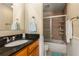 Well-lit bathroom with a granite vanity, shower with glass door, and ceramic tile surround at 1445 Monroe Ne Dr # 14B, Atlanta, GA 30324
