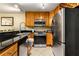 Kitchen showcasing wood cabinets, stainless steel appliances, granite countertops, and tile floors at 1445 Monroe Ne Dr # 14B, Atlanta, GA 30324