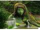 Lush green sculpture of a Personal face with colorful plants as hair, set next to a peaceful waterfall and pond at 1445 Monroe Ne Dr # 14B, Atlanta, GA 30324