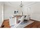 Bright formal dining room featuring hardwood floors, chandelier, wainscoting, and a modern table setting at 2165 Parkview Nw Run, Atlanta, GA 30318