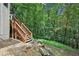 Wooden stairs on a gravel and stone surface leading to a backyard surrounded by lush green foliage at 1285 Willow Park Way, Cumming, GA 30041