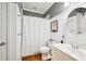 A well-lit bathroom with white wainscoting, toilet, and a white shower curtain at 1285 Willow Park Way, Cumming, GA 30041