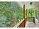 Relax on this covered deck with wooden railings and posts surrounded by lush green trees at 1285 Willow Park Way, Cumming, GA 30041