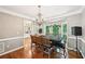 Dining room with hardwood floors, modern chandelier, view to the kitchen, and a large window overlooking green trees at 1285 Willow Park Way, Cumming, GA 30041