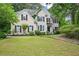 Charming two-story home featuring a manicured lawn and a traditional facade with black shutters and lush landscaping at 1285 Willow Park Way, Cumming, GA 30041