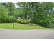 Landscaped front yard with mature trees, green lawn, and a view of the charming home at 1285 Willow Park Way, Cumming, GA 30041