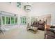 Open-concept living room with a view to a sunroom and kitchen featuring high ceilings and large windows for natural light at 1285 Willow Park Way, Cumming, GA 30041
