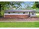 Rear exterior view of home with brick foundation and large, grassy backyard at 1112 Evelyn Drive Dr, Forest Park, GA 30297