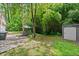 Large backyard featuring a patio with dining set, storage shed, and a canopy of trees at 269 Terrydale Se Dr, Marietta, GA 30067