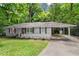 Charming single-story home featuring a classic brick facade, white picket fence, and an inviting carport at 269 Terrydale Se Dr, Marietta, GA 30067