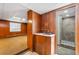 Basement area featuring wood paneling, a sink, and a tiled shower room, offering functional amenities at 2917 Rockingham Nw Dr, Atlanta, GA 30327