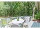 Outdoor deck with a white table and seating, overlooking lush greenery at 4023 Anvil Block Rd, Ellenwood, GA 30294