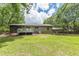 Large backyard with a deck, carport, and lush green lawn at 4023 Anvil Block Rd, Ellenwood, GA 30294