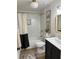 Bright bathroom with a shower-tub, subway tile surround, wood-look floors, and modern fixtures at 4023 Anvil Block Rd, Ellenwood, GA 30294