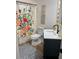 Bright bathroom features a toilet, blue vanity, patterned rug and floral shower curtain at 4023 Anvil Block Rd, Ellenwood, GA 30294