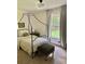 Comfortable bedroom featuring a curtained four-poster bed and a large window view at 4023 Anvil Block Rd, Ellenwood, GA 30294