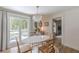 Dining room with a white table, wood chairs, and a chandelier, with light streaming from sliding glass doors at 4023 Anvil Block Rd, Ellenwood, GA 30294
