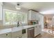 Bright kitchen features large windows over the sink offering wooded views, with white cabinets and stainless appliances at 4023 Anvil Block Rd, Ellenwood, GA 30294