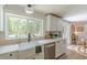 Bright kitchen featuring white cabinets, a farmhouse sink, and a large window with backyard views at 4023 Anvil Block Rd, Ellenwood, GA 30294