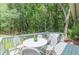 Relax on the patio with comfortable seating, a table, and views of the surrounding trees at 4023 Anvil Block Rd, Ellenwood, GA 30294