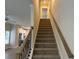 Carpeted staircase with dark metal balusters and natural wood handrail leading to the upper level at 5463 Blossomwood Sw Trl, Mableton, GA 30126