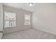 This well-lit bedroom features neutral carpet and two large windows at 10775 Brunson Dr, Johns Creek, GA 30097
