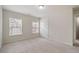 This bedroom features neutral carpeting, white walls, and two windows that let in natural light at 10775 Brunson Dr, Johns Creek, GA 30097
