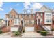 Charming townhomes featuring brick and stone exteriors, attached garages, and manicured landscaping at 10775 Brunson Dr, Johns Creek, GA 30097