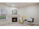 View of the living room featuring a fireplace with mantle, table set, and window at 10775 Brunson Dr, Johns Creek, GA 30097