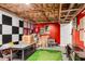 Unfinished basement area with red and black checkered wall, and indoor putting green at 1209 Colony Cir, Marietta, GA 30068