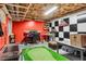 Unfinished basement area with red and black checkered wall, home office, and indoor putting green at 1209 Colony Cir, Marietta, GA 30068