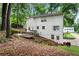 Back exterior of the house with a deck and patio, surrounded by mature trees and landscaping at 1209 Colony Cir, Marietta, GA 30068