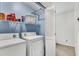 This laundry room contains a side-by-side washer and dryer with shelving above at 1209 Colony Cir, Marietta, GA 30068