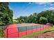 Well-maintained tennis court with vibrant colors, perfect for recreational play and surrounded by natural landscape at 1209 Colony Cir, Marietta, GA 30068