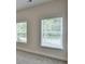 Sunlit bedroom featuring neutral carpeting, white walls, and two windows with blinds at 5477 Blossomwood Sw Trl, Mableton, GA 30126