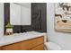 A modern powder room features dark tiling, updated fixtures and attractive decor at 81 Walthall Se St, Atlanta, GA 30316