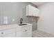 A bright laundry room is decorated with gray tiles and white cabinets at 81 Walthall Se St, Atlanta, GA 30316