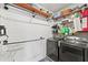 Functional laundry room with modern washer and dryer, storage shelves, and hanging racks at 110 Ashbury Circle Cir, Dallas, GA 30157