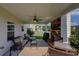 Cozy covered patio with a ceiling fan, brick fireplace, and comfortable seating area at 110 Ashbury Circle Cir, Dallas, GA 30157