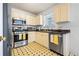 Functional kitchen with stainless steel appliances, classic cabinets, and patterned flooring at 11833 Spring Lake Way, Fayetteville, GA 30215
